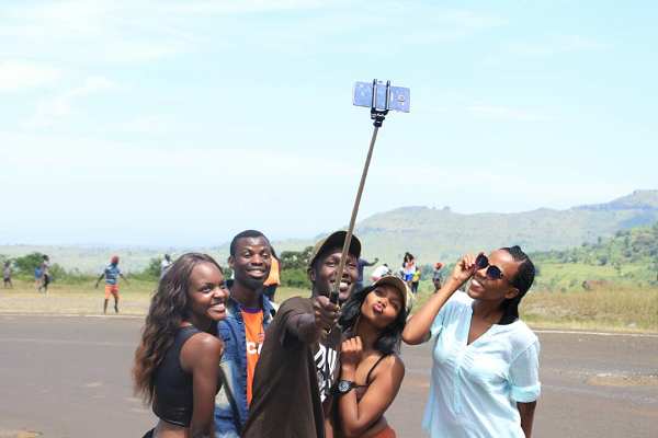 Baker Masheta holds a selfie stick as friends pose for the picture.