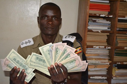 A police officer with some of the counterfeit notes