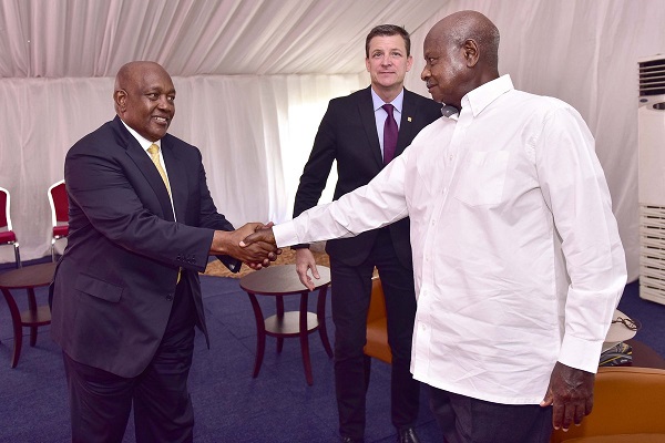 President Museveni shakes hands with MTN Uganda Chairman Charles Mbire as Rob Shuter looks on